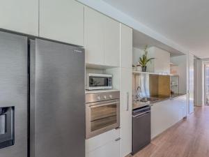 a kitchen with white cabinets and stainless steel appliances at Blue on Blue Apartment 1011 in Nelly Bay