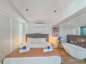 a bedroom with a large bed and a bath tub at Blue on Blue Apartment 1011 in Nelly Bay