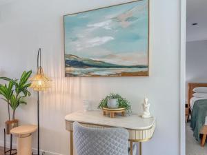 a room with a table and a painting on the wall at Blue on Blue Apartment 1011 in Nelly Bay