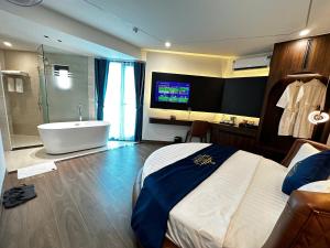 a bathroom with a bed and a tub and a television at A3 Villa Hotel - Gia Lâm in Thạch Cầu