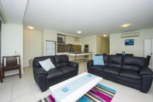 a living room with a couch and a table at Blue on Blue Apartment 813 in Nelly Bay