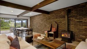 a living room with a brick wall and a fireplace at The Castle Wentworth Falls in Wentworth Falls