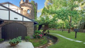 a brick house with a garage and a yard at The Castle Wentworth Falls in Wentworth Falls +16 photos