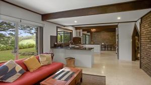 an open kitchen and living room with a red couch at The Castle Wentworth Falls in Wentworth Falls