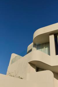 a white building with a blue sky in the background at Fira Uluwatu in Uluwatu