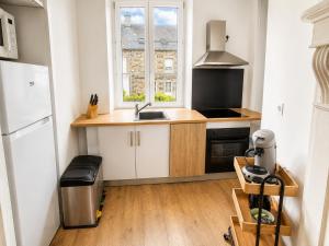 a small kitchen with a sink and a refrigerator at Maison 6 pers - Entre mer & Mont-Saint-Michel in Beauchamps