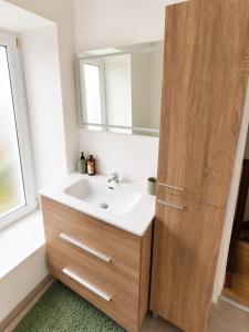 a bathroom with a sink and a wooden door at Maison 6 pers - Entre mer & Mont-Saint-Michel in Beauchamps
