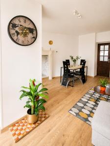 a living room with a clock on the wall at Maison 6 pers - Entre mer & Mont-Saint-Michel in Beauchamps