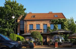 a building with tables and umbrellas in front of it at Pliusas Residence in Jurbarkas