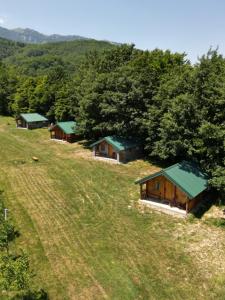 a group of cottages on a hill in a field at Cottages Serdar in Mojkovac