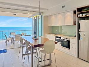 a kitchen and dining room with a view of the ocean at 1 Bright Point Apartment 4203 in Nelly Bay +8 photos