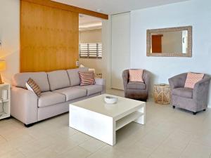 a living room with a couch and two chairs at 1 Bright Point Apartment 4203 in Nelly Bay