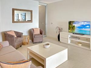 a living room with a tv and a coffee table at 1 Bright Point Apartment 4203 in Nelly Bay
