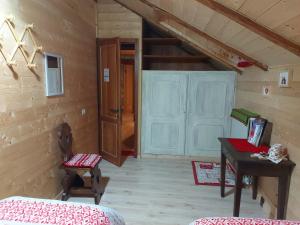 a room with a door and a table and a desk at B&B ABETE BIANCO in Auronzo di Cadore
