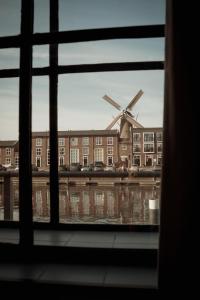a window view of a building with a windmill at Boutique Hotel De Oude Veste in Hellevoetsluis