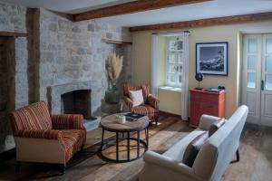 a living room with two chairs and a fireplace at İda Blue Adatepe in Küçükkuyu