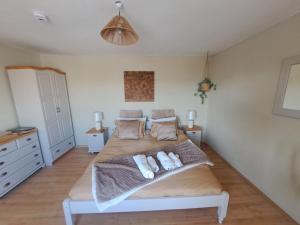 a bedroom with a large bed with two towels at Muddy Puddles Farm in Kovachevets