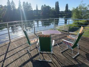 three chairs and a table on the deck of a boat at La Maison Trente in Chooz
