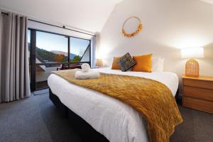 a bedroom with a large bed with a large window at Sarahs Scenic Stay Mountain Lake Views in Queenstown