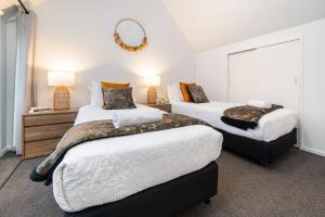 a bedroom with two beds and a mirror at Sarahs Scenic Stay Mountain Lake Views in Queenstown