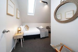 a small bedroom with a bed and a mirror at Sarahs Scenic Stay Mountain Lake Views in Queenstown