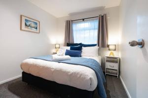a bedroom with a large bed with a window at Sarahs Scenic Stay Mountain Lake Views in Queenstown +40 photos