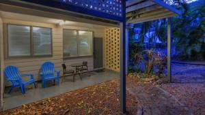 a patio with two chairs and a table and a house at Loyang Apartment 1 in Arcadia