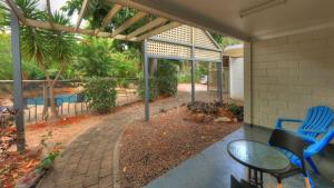 a patio with a blue chair and a table at Loyang Apartment 1 in Arcadia