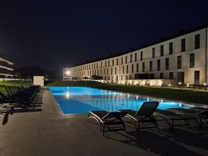 a building with chairs and a swimming pool at night at GuestReady - Beachfront retreat with pools in Apúlia