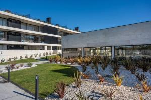 a building with a courtyard with plants in front of it at GuestReady - Beachfront retreat with pools in Apúlia