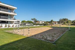 a volley ball court in a park in front of a building at GuestReady - Beachfront retreat with pools in Apúlia +35 photos
