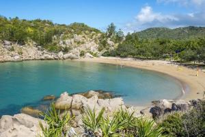 a beach with a group of people in the water at Alma Bay Holiday Unit 4 in Arcadia +4 photos