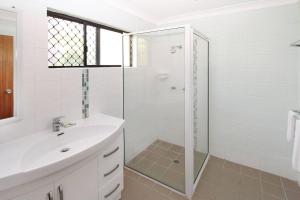 a white bathroom with a shower and a sink at Alma Bay Holiday Unit 4 in Arcadia