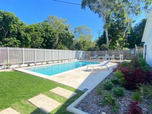 a swimming pool in a yard next to a fence at Alma Bay Holiday Unit 4 in Arcadia
