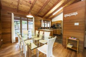 a dining room with a glass table and white chairs at Magnetic Effect in Arcadia