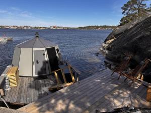 a small house on a dock on a body of water at Stockholm Archipelago Igloo Hut in Tynningö