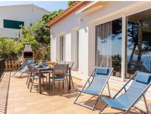 a patio with blue chairs and a table with a table at La Terrasse 1-Vue Mer Panoramique & Piscine, BBQ in Begur