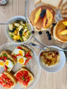 a table topped with plates of food with breakfast foods at La Locanda Chic B&B in Grosseto