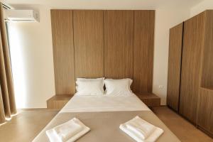 a bedroom with a large bed with two white pillows at Abeille Rooms in Himare