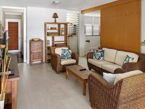 a living room with a couch and chairs and a table at 1 Bright Point Apartment 2303 in Nelly Bay