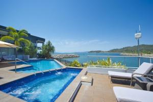 a swimming pool with a view of the water at 1 Bright Point Apartment 2303 in Nelly Bay