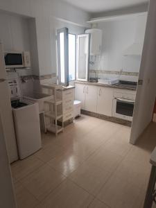 a large kitchen with white cabinets and appliances at Apartamento Junto AL MAR Quesada 2 in Almería +44 photos