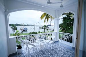 a balcony with a table and chairs and a view of the water at Le Mont Lagoon Home Stay in Cochin