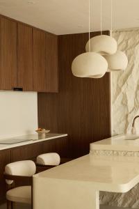 a kitchen with two lights and a table and chairs at Fira Uluwatu in Uluwatu +50 photos
