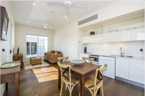 a kitchen and living room with a wooden table and chairs at Reflections Emerald Villa 1 in Picnic Bay