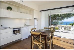 a kitchen with a table and chairs and a view of the ocean at Reflections Emerald Villa 1 in Picnic Bay