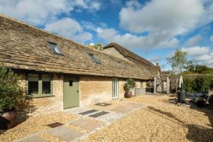 a cottage with a green door and a patio at The Foaling Box at Lanhill in Oakhill