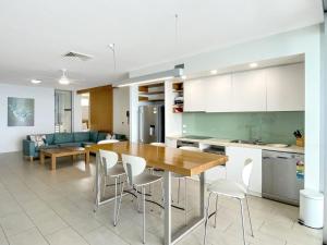a kitchen and living room with a wooden table and chairs at 1 Bright Point Apartment 4502 in Nelly Bay