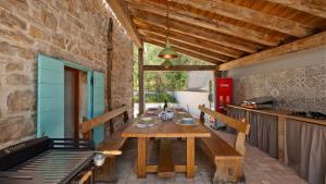 a wooden table and bench in a kitchen with at Old House Grota by Villas Guide in Umag