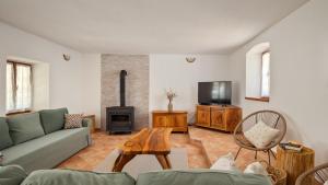 a living room with a couch and a tv at Old House Grota by Villas Guide in Umag